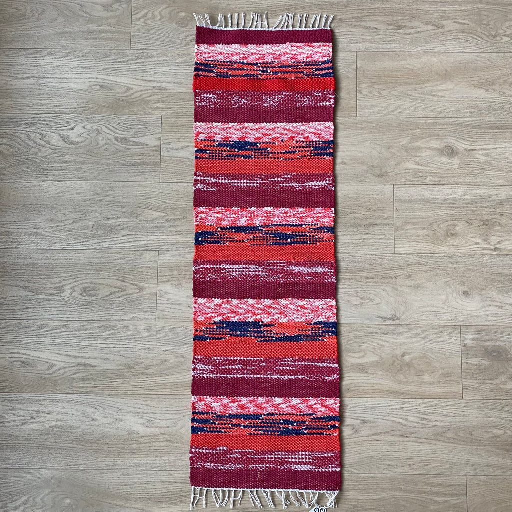 Marjatriip – punastes toonides kaltsuvaip 130 × 40 cm